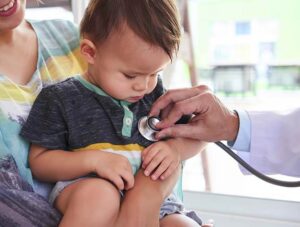 Pediatric urgent care in Niles, IL – doctor examining child with stethoscope