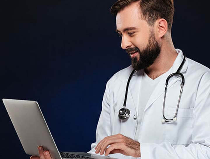 Doctor advising the patient online with laptop. African-american doctor during his work with patients, explaining recipes for drug. Daily hard work for health and lives saving during epidemic.